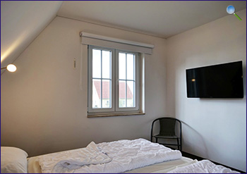 Schlafzimmer mit Fernseher im Dachgeschoss