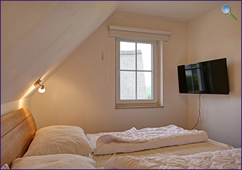Ein Schlafzimmer mit Fernseher im Dachgeschoss